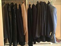 Nine jackets hanging on rail in various colors and styles