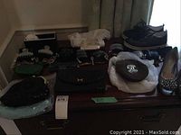 Overview of three purses, shoes and decorative hair combs on dresser