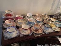 Front view of assorted teacups and saucers displayed on table
