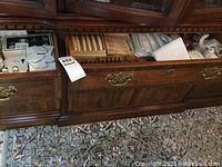 Drawer with various sets of butter spreaders, linens, napkin rings, place card holders, place cards, salt and peppers, candles, coasters and more.
