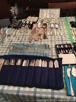 Overview of assorted cutlery spread on checkered cloth