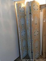 Photo showing full view of the three-panel folding divider in upright position, highlighting ornate fabric upholstery and wood framing.