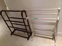 Two wooden quilt racks placed side by side, one light and one dark wood.