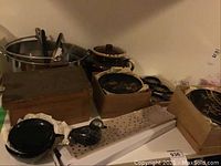 Overall lot showing plastic plates, ceramic bean pot, glass bird, boxes with dishes and a stainless steel bucket with utensils.
