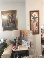 Full view of wall corner with multiple framed artworks including poster, botanical print, birch forest print, and small sea gulls print on a side table.