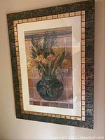Framed art print showing floral arrangement in a dark green vase with dried flowers