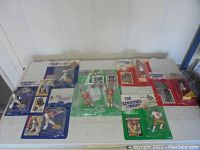 Wide shot of all seven sports action figure lots in original Starting Lineup packaging on a white table