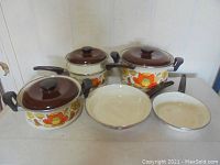 Front view of Country Flowers pots and pans including lids and handles