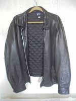 Front view of GAP black leather jacket showing quilted lining and collar.