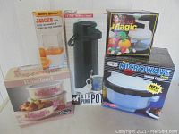 Lot of 5 boxed kitchen items including casserole set, juicer, thermal carafe, chopper, and microwave cooker.