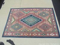 Full view of the rectangular rug showing the central diamond medallion and surrounding geometric patterns.