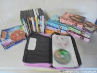 DVD wallet open showing a couple of the loose DVDs inside alongside the box set stacks.