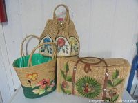 Three tourist bags from Acapulco; handwoven with floral designs in natural fibers.