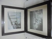 Two framed black-and-white airplane art prints standing together showing dark frames and white mats.