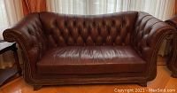Front view of brown tufted leather sofa