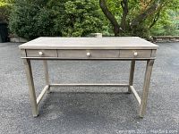 Front view of the Toulouse desk, showing three drawers with white quartz stone knobs and distressed gray wash finish.