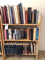 Books arranged on wooden shelves, showing variety of hardbound volumes on historical, artistic, and cultural topics.