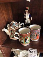 Photo showing the Sadler hexagonal teapot and matching cups featuring colorful historical illustrations, and two figurines including Napoleon figure
