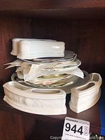 Stack of decorative ceramic plates with two matching rectangular serving dishes with embossed floral patterns.