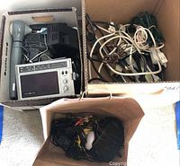 Box containing General Electric AM/FM radio, wired headphones, handheld microphone, and other accessories.