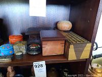 Seven trinket boxes arranged on a wooden shelf, showing variety of materials and shapes.