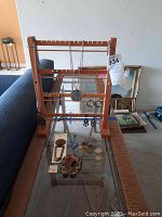 Wooden jewelry holder with necklaces, rings, coins and earrings on glass shelf