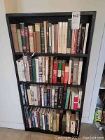 Front view of black bookcase filled with various hardcover books mainly on history, war, and philosophy.