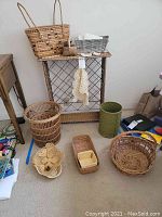 Image showing multiple wicker baskets, a wicker wine rack, crocheted doilies, white napkins, and a green decorative container arranged on and around the wine rack.