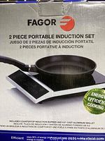 Photo showing the Fagor 2 piece portable induction set packaging, highlighting the induction burner paired with the 9.5 inch cast aluminum skillet