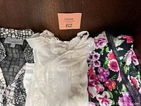 Four pieces of clothing laid out side by side showing variety of styles and colors
