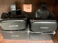 Two sealed VR headsets, Astoria VR on the left and VR Shinecon on the right, showing front view with logos.