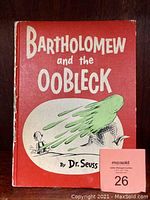Front cover of the red hardcover Dr. Seuss book titled 'Bartholomew and the Oobleck' with illustration of green slime and a character.
