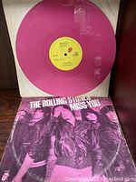 Hot pink vinyl record on display with album cover showing the band and text "THE ROLLING STONES MISS YOU."