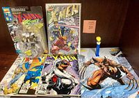 Overall lot showing Wolverine PEZ dispenser, four assorted X-MEN comic books, and pull-out Wolverine poster from 1997.