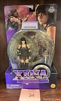 Photo of front of sealed Xena Warrior Princess action figure in original blister packaging showing figure, weapons, and round stand with packaging text and graphics.