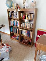 Front view of two wood laminate bookcases filled with books and decorative items.