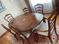 Overview of six wooden dining chairs around a round table