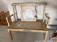 Front and side view of wooden bench showing armrests, seat, and decorative backrest.