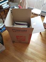 Cardboard box filled with multiple vinyl LP records packed upright with bubble wrap and packing materials visible around the box.