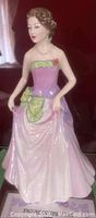 Front view of the Jessica porcelain figurine in pink and lavender gown with green accents and red rose detail.