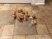 Photo showing 8 collectable Pendleton bunny figurines arranged on tile floor.