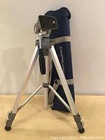 Full view of Velbon tripod fully extended with blue carrying case behind it