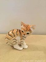 Side view of vintage Lomonosov USSR cat figurine with orange and brown stripes, sitting position