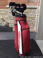 Full side view of red, white, and black Accuform staff golf bag with golf clubs inside.