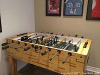 Angled side view of entire table showing wood frame, legs and rod handles