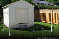 Backyard shed with galvanized screw piles installed at each corner in grass