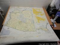 Full view of the large paper map of Arizona laid flat on a table, showing state boundaries, major roads, and geographic features.