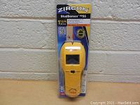 Front view of Zircon StudSensor HD55 stud finder in sealed packaging against a white brick wall.