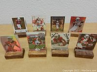 Front-facing view of seven Arizona Cardinals Larry Fitzgerald football cards in plastic sleeves held by wooden stands.