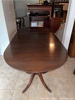Full top view of the mahogany dining table showing wood finish and three sections.